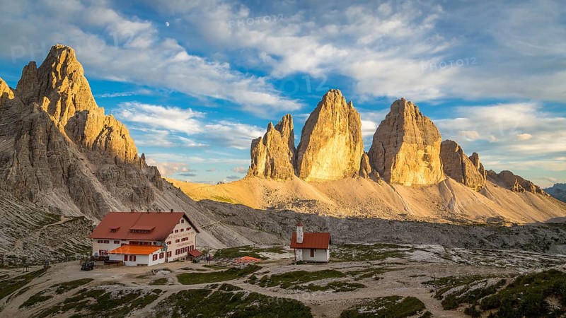 View of mountain hut Dreizinnenhuette and chapel with rock massif Paternkofel and mountain range drei Zinnen, panorama