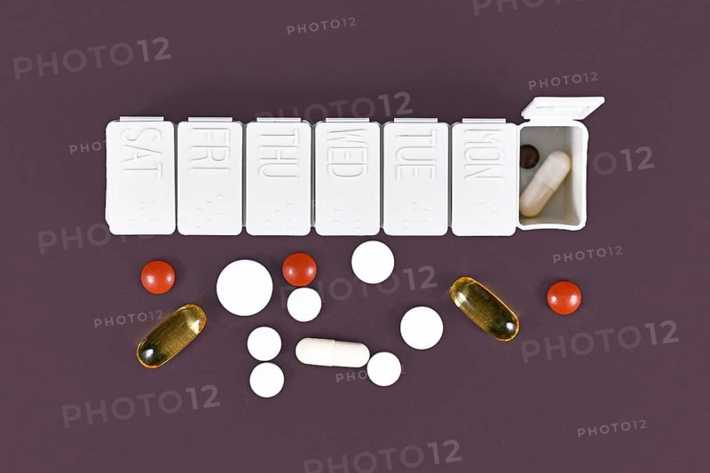 Pill box with many different medical pills and casuals,