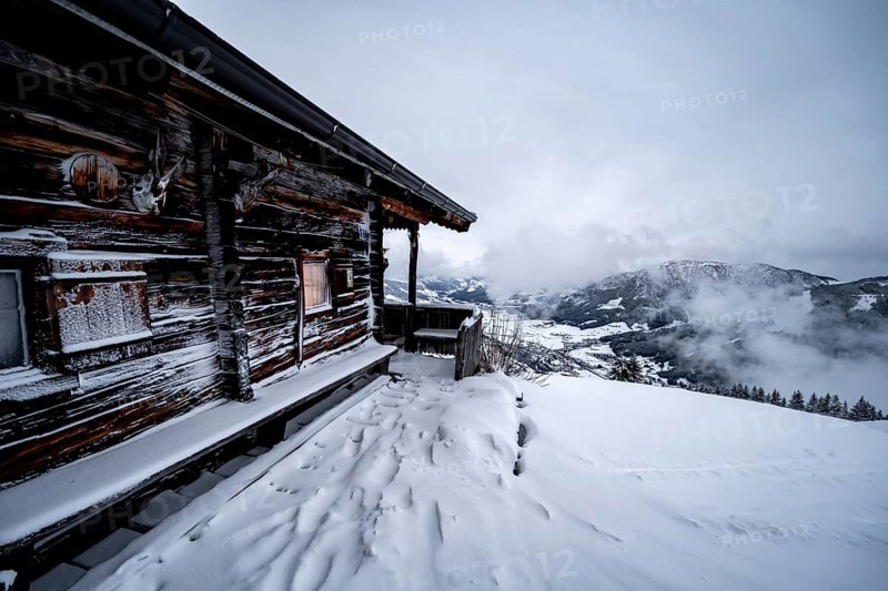 Snowfall, mountain hut in the snow