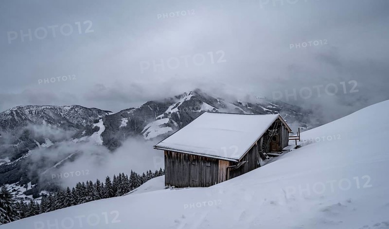 Snowfall, mountain hut in the snow