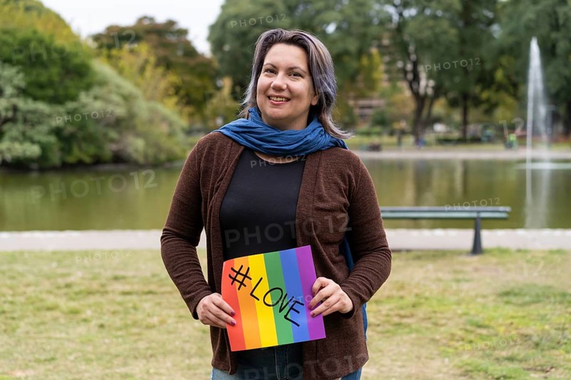 Love. Cheerful queer woman holding a message supporting the LGBT community,