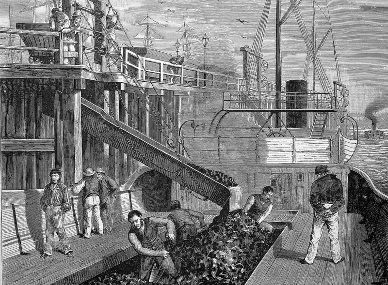 Loading of a coal steamboat in a harbour in England, coal is shovelled into the storage bunker