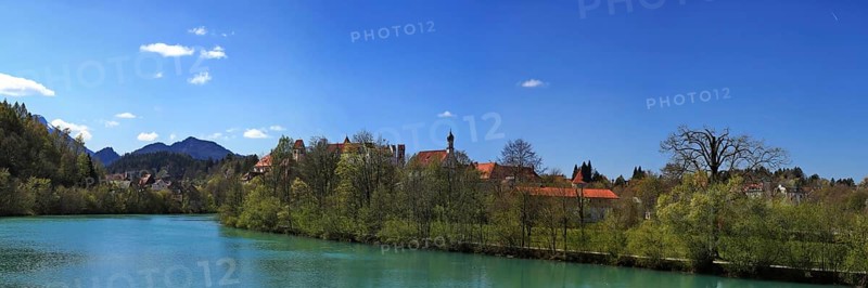 The Lech near Fuessen with a view of the Benedictine monastery of St. Mang and high castle. Ostallgaeu Swabia, Bavaria