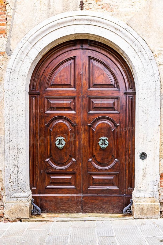 Round arched house entrance door, edged with white marble