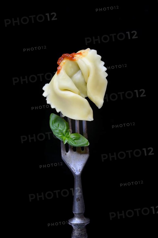 A tortelloni with tomato sauce on a fork, pasta