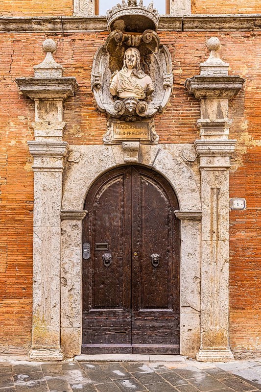 Historic round arched house entrance gate of a palace, framed with columns of light marble
