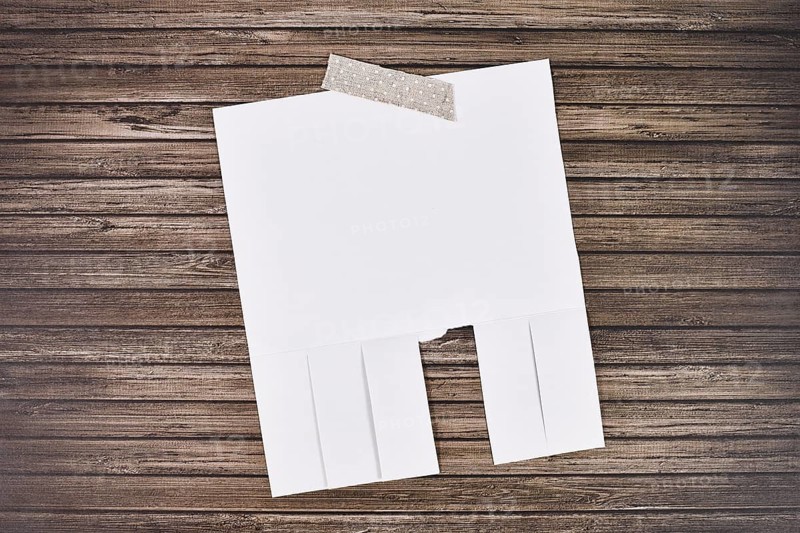 White empty tear-off stub paper note without text on wooden wall,