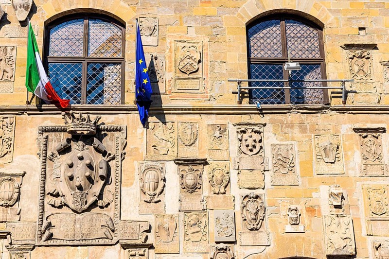 The Italian and European flags fly on the facade of Palazzo Pretorio, Arezzo
