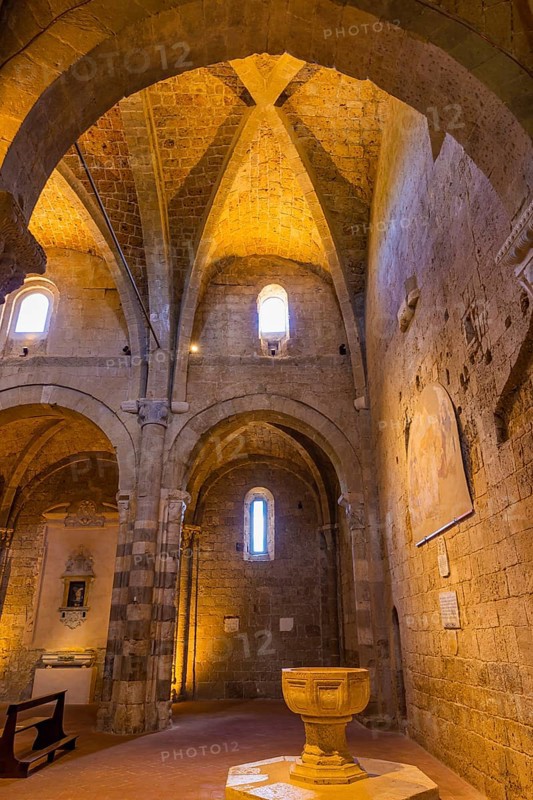The illuminated ceiling vault of Sovana Cathedral, below the baptismal font