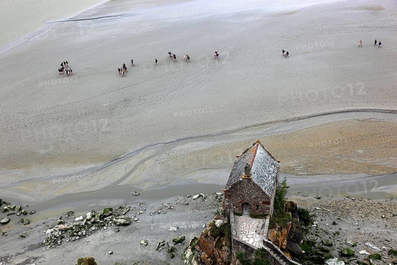 View from the monastery hill of Mont Saint-Michel towards the walkers on the mudflats and the Chapelle Saint-Aubert du Mont-Saint-Michel, Basse-Normandie
