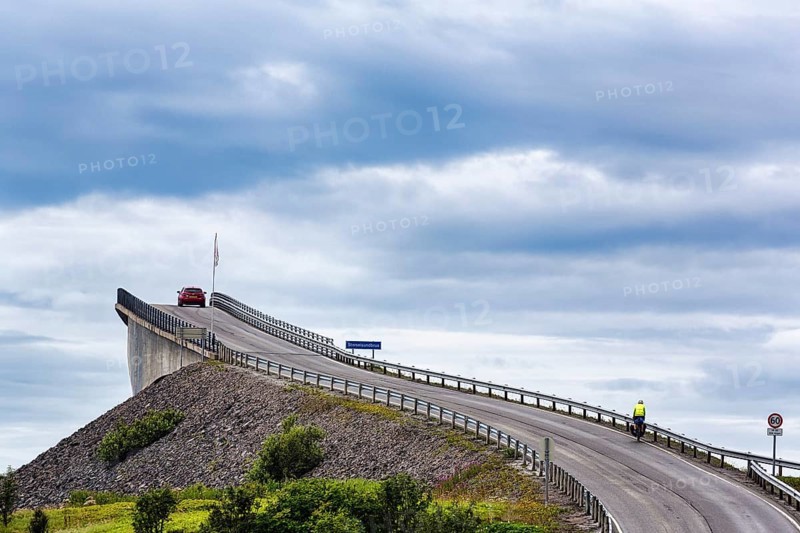 Cyclist and car on Atlantic Road, curvy bridge Storseisundbrua