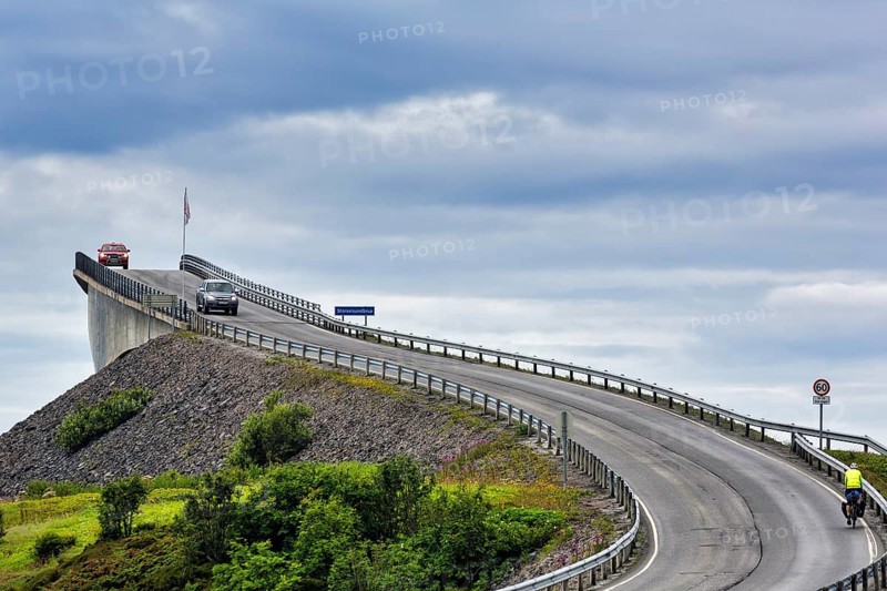 Cyclist and car on Atlantic Road, curvy bridge Storseisundbrua