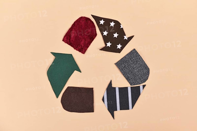 Recycling arrow symbol made from old textile pieces,
