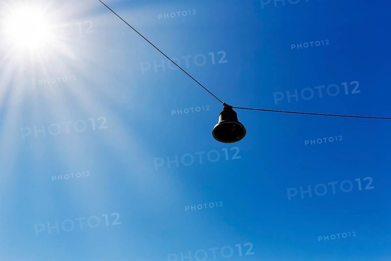 Single discarded bell hanging on steel cable, sound body