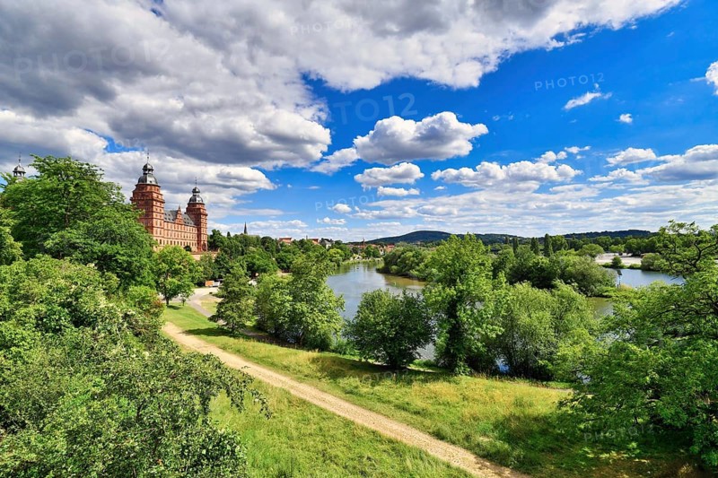 View over beautiful German city Aschaffenburg with Main river, palace called Schloss Johannisburg and green park on sunny summer day
