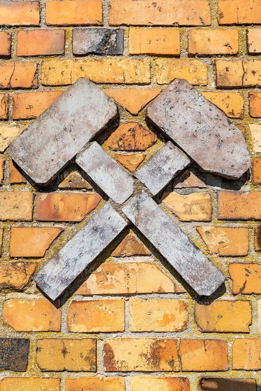Mining symbol hammer and iron, avenue of construction machinery from opencast lignite mining