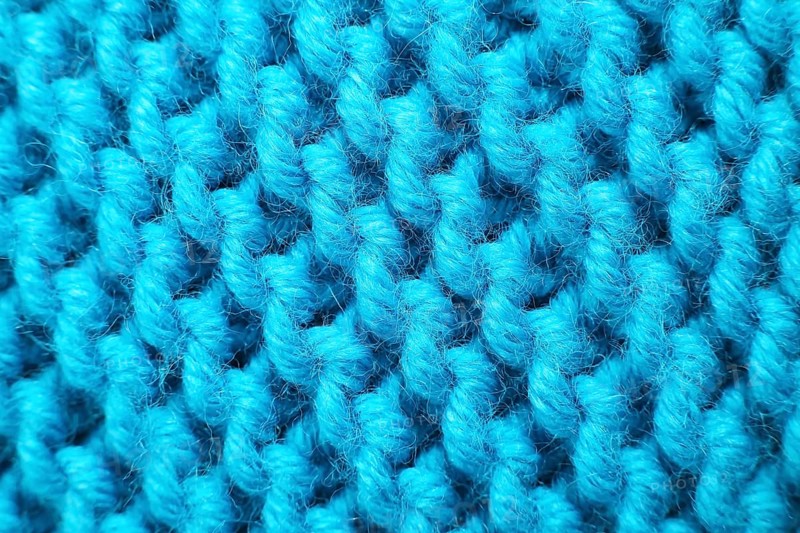 Knitted wool blanket in the colour magenta. Macro,