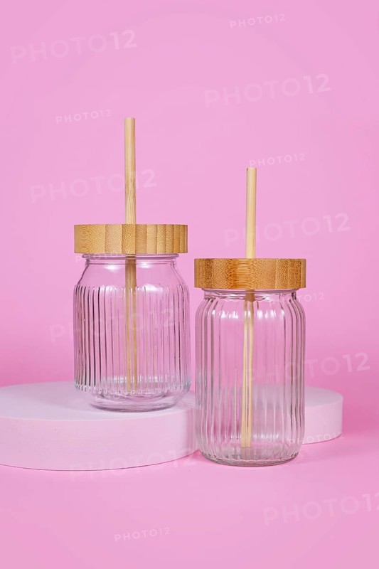 Natural material jars with drinking straws made from glass, wood and bamboo