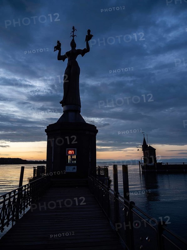 Statue of Imperia at the harbour entrance of Constance in the morning light in front of sunrise, Old Town