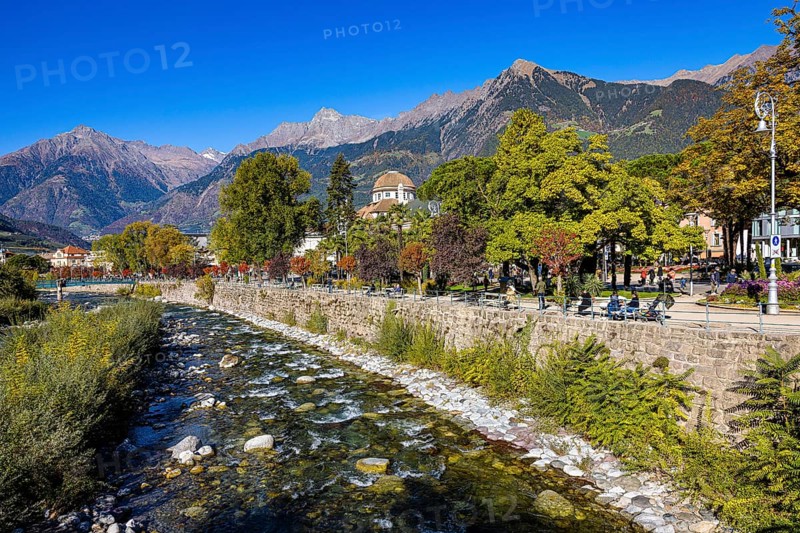 The river Passer flows along the spa garden and spa hotel of Merano, behind it the Mutspitze and mountains of the Texelgruppe