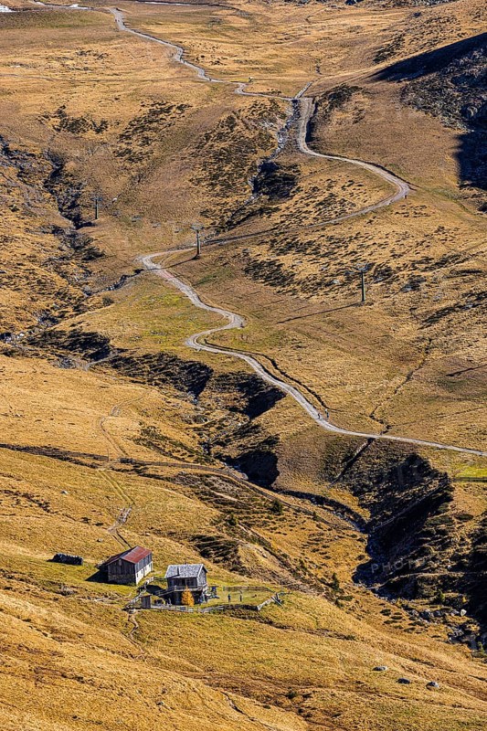Winding hiking trail, in front a small mountain hut