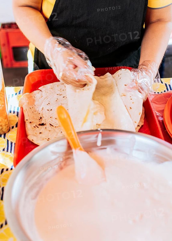 Homemade Nicaraguan Quesillo, traditional Central American food quesillo. Hands making a Nicaraguan quesillo. Close up of hands making a traditional quesillo with pickled onion