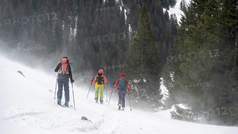Three ski tourers, snowstorm