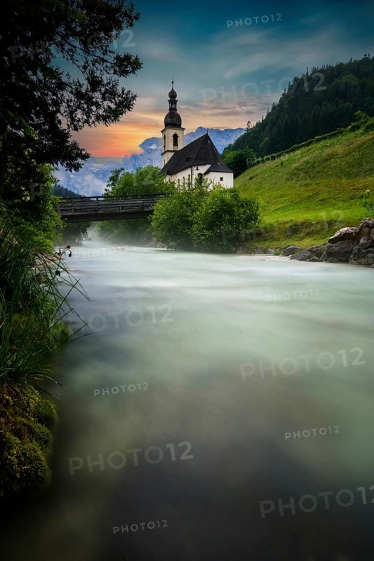 Parish church of St. Sebastian, with wooden bridge over a stream