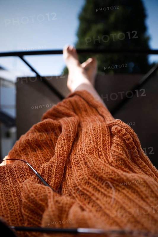 Knitted blanket with knitting needles,