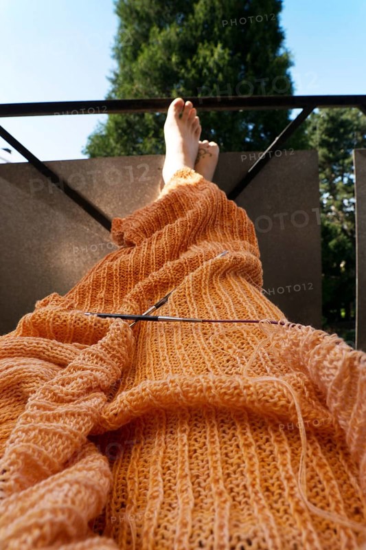 Knitted blanket with knitting needles,