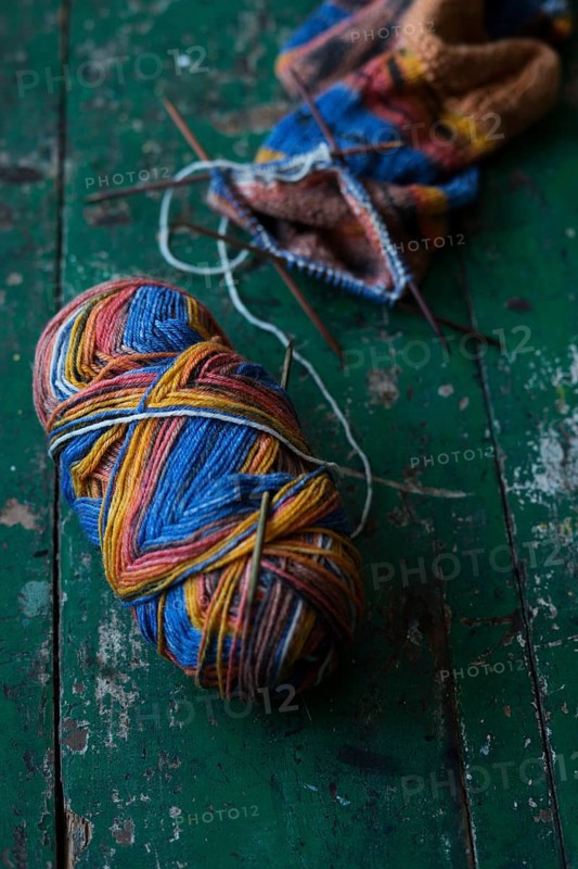 Handwork, knitted sock with knitting needles and wool
