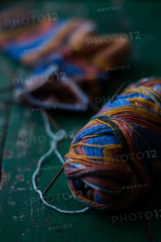 Handwork, knitted sock with knitting needles and wool