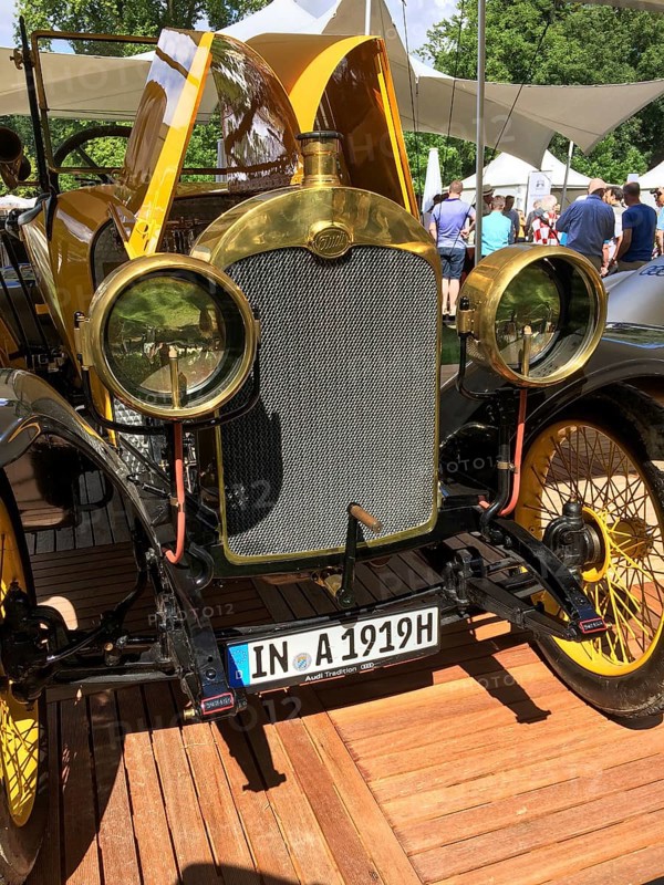 Front view front with radiator grill round lamps spoke wheel of historic racing car from early 20th century 1919 Audi Phaeton Type C Alpine winner, Classic Days