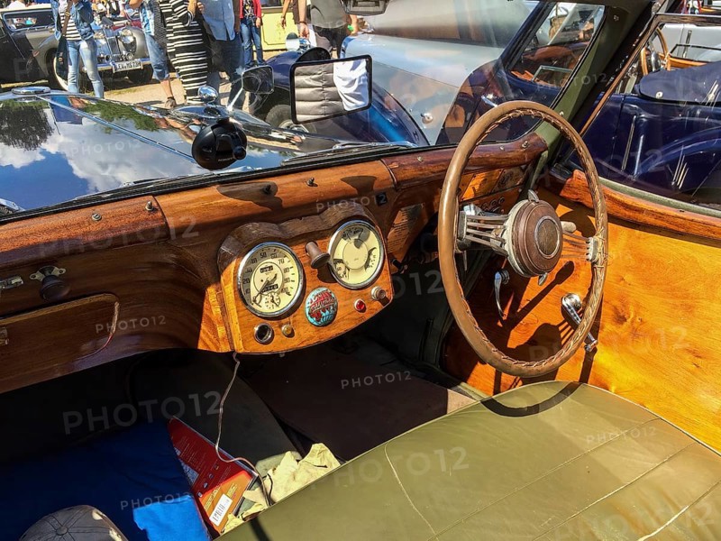 View on wooden dashboard with classic analogue round instruments of historic sports car convertible Triumph Roadster 2000 from 40s 1949, Classic Days