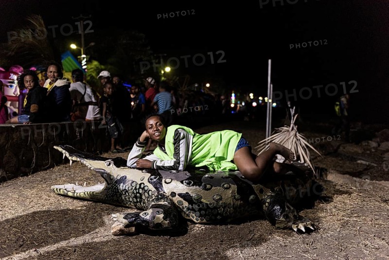 Woman lying on papier mache crocodile, dummy