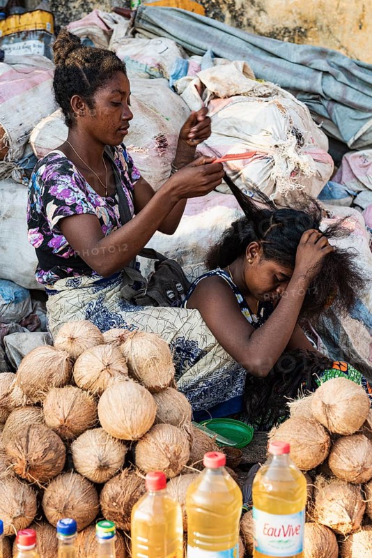 Two woman braiding hair, market stall