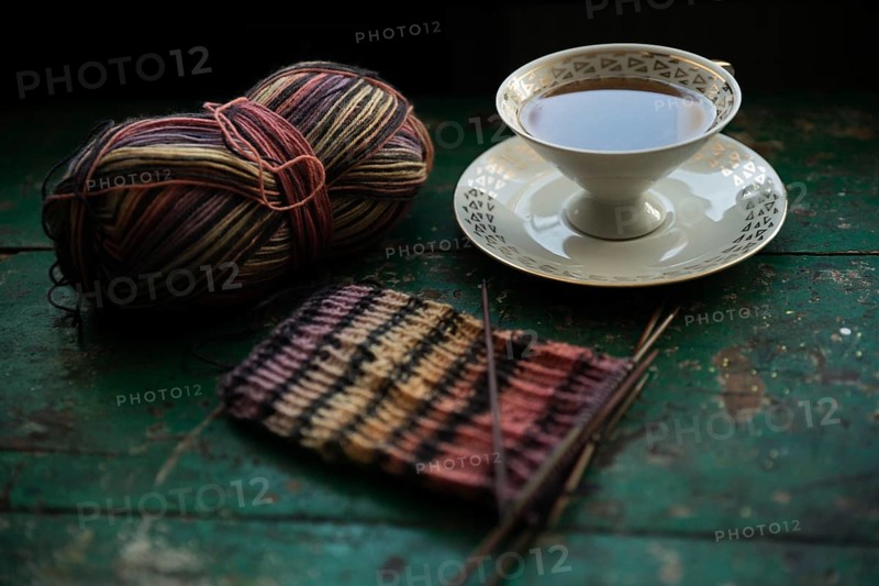Handmade, Knitted piece with knitting needles and coffee