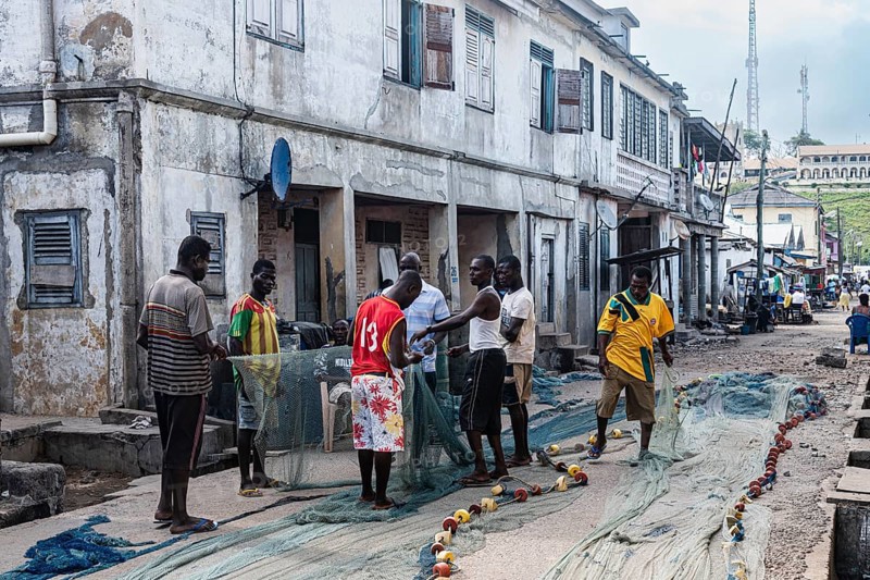 Fishermen mending nets, Elmina