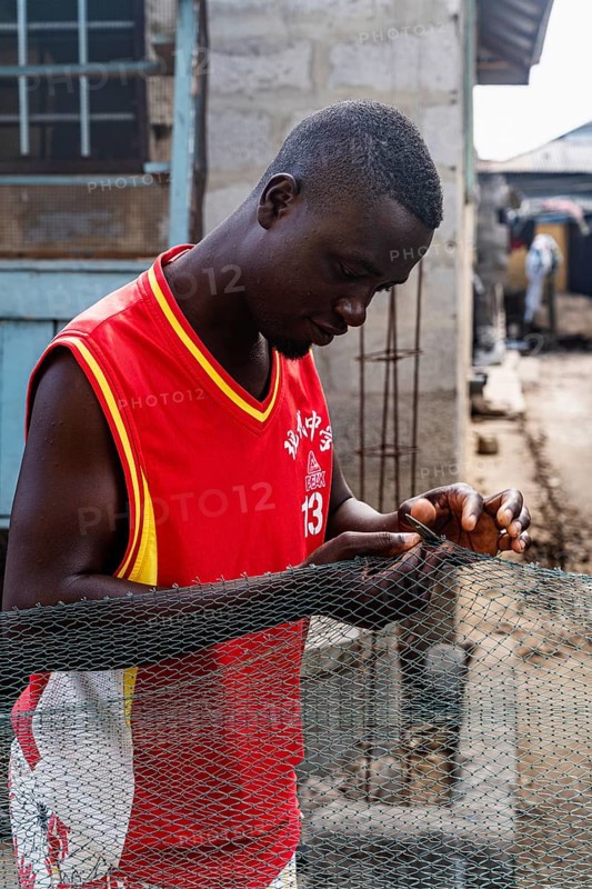 Fisherman mending nets, Elmina