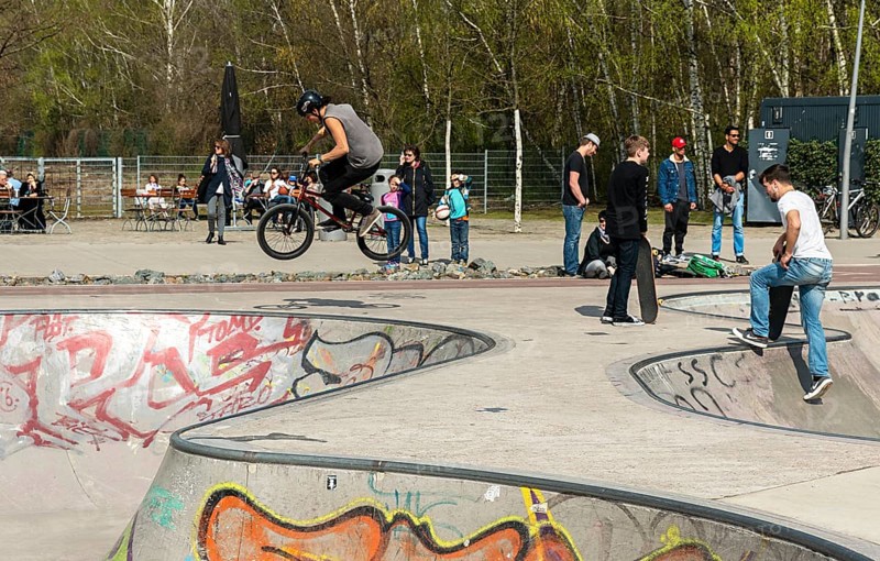 Skateboarders and cyclists at a skate pool in the Park am Gleisdreieck in Berlin-Mitte, Berlin