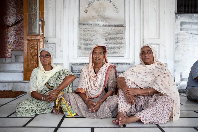Indian woman in Indian robes and barefoot at the Hari Mandir or Golden Temple, Amritsar