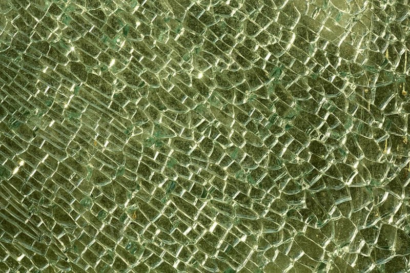 Shattered and broken glass pane with fractures, cracks and shapes