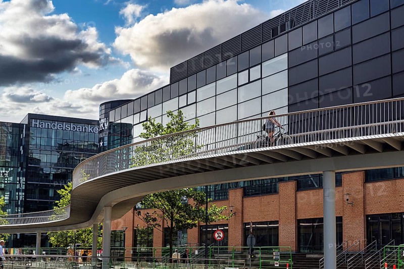 Cyclists on bridge over inner harbour basin, snake-shaped Cykelslangen bicycle bridge