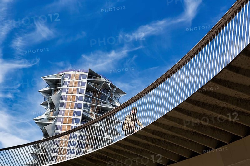 Cyclists on bridge at Kaktus Tower skyscraper, Cykelslangen bicycle bridge