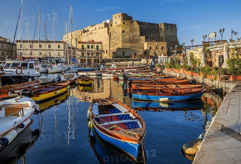 Fishing and boating port of Santa Lucia with Castel dell Ovo in early morning sun, Naples