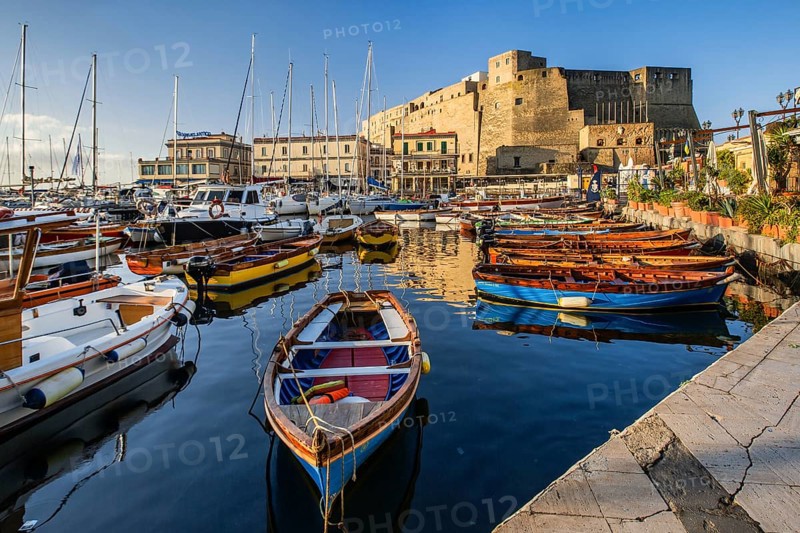 Fishing and boating port of Santa Lucia with Castel dell Ovo in early morning sun, Naples