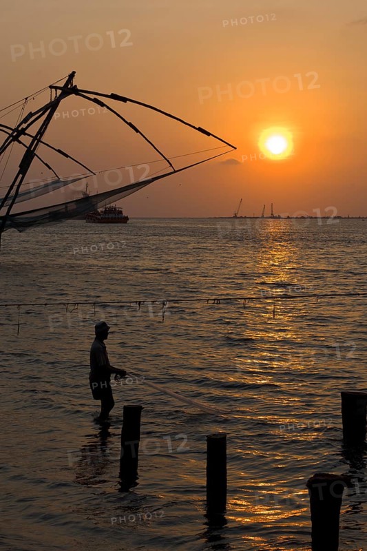 Fisherman and Kochi chinese fishnets on sunset. Fort Kochin