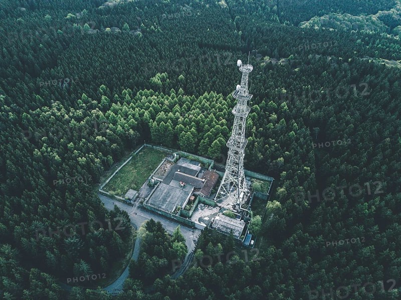 AERIAL: Drone Shot of old Abandones Radio Tower Station in Rich Green Forest surrounded by Trees HQ