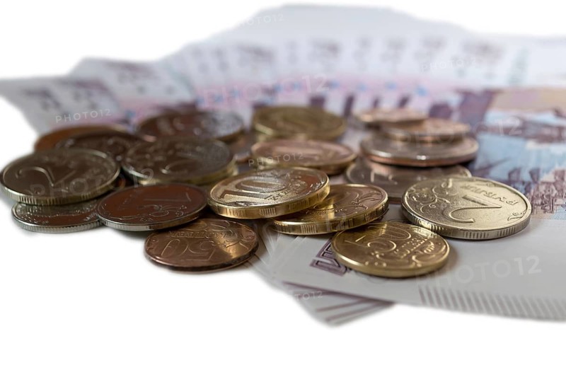 Rubles coins against background of 500 rubles banknotes fan close up