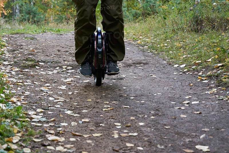 Front view of male legs on a unicycle in the forest